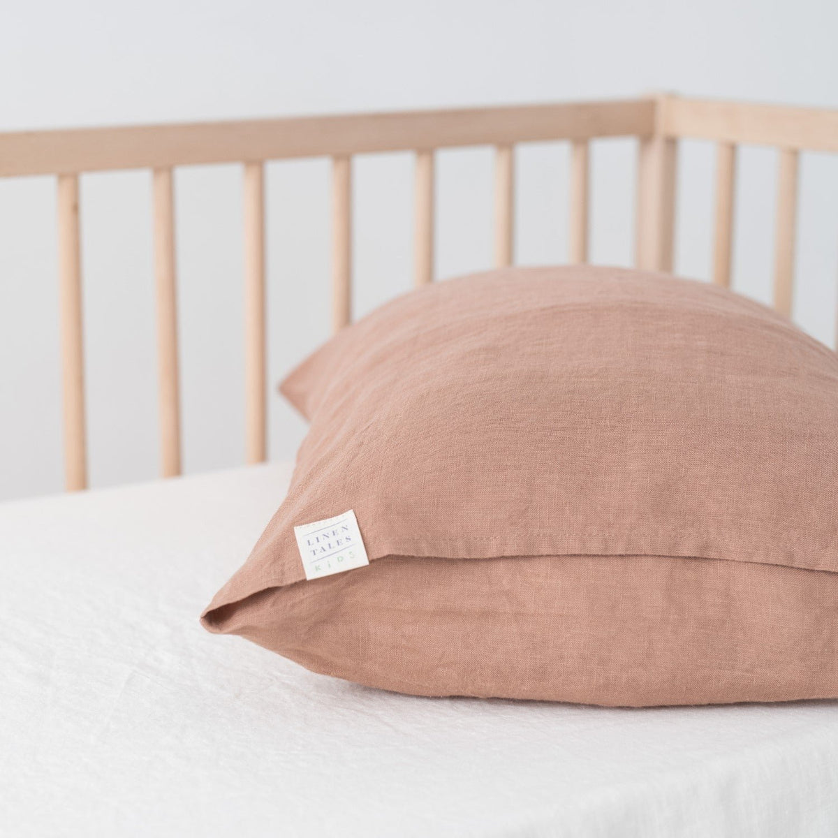 8. Cafe creme linen pillowcase on crib mattress with Linen Tales brand tag