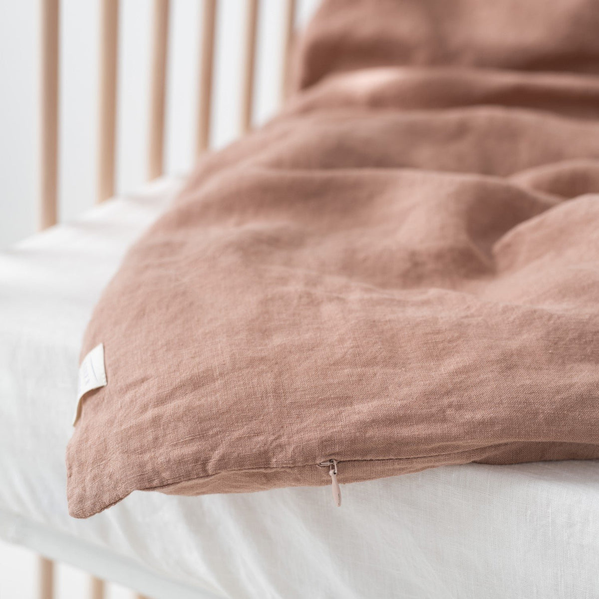 6. Cafe creme linen duvet cover with visible zipper detail on crib mattress