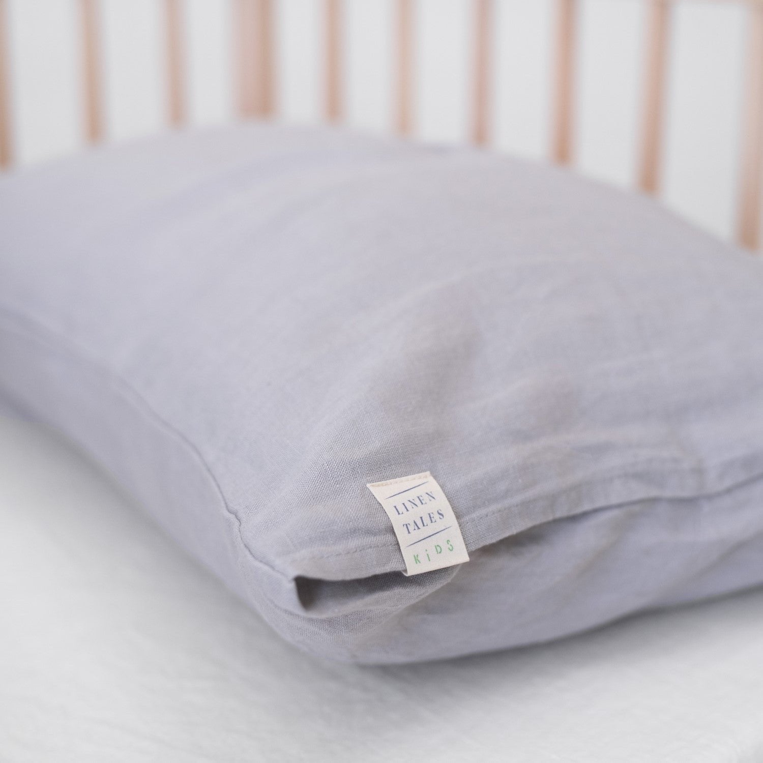 3. Close-up of light grey linen pillowcase with Linen Tales Kids label, highlighting brand detail