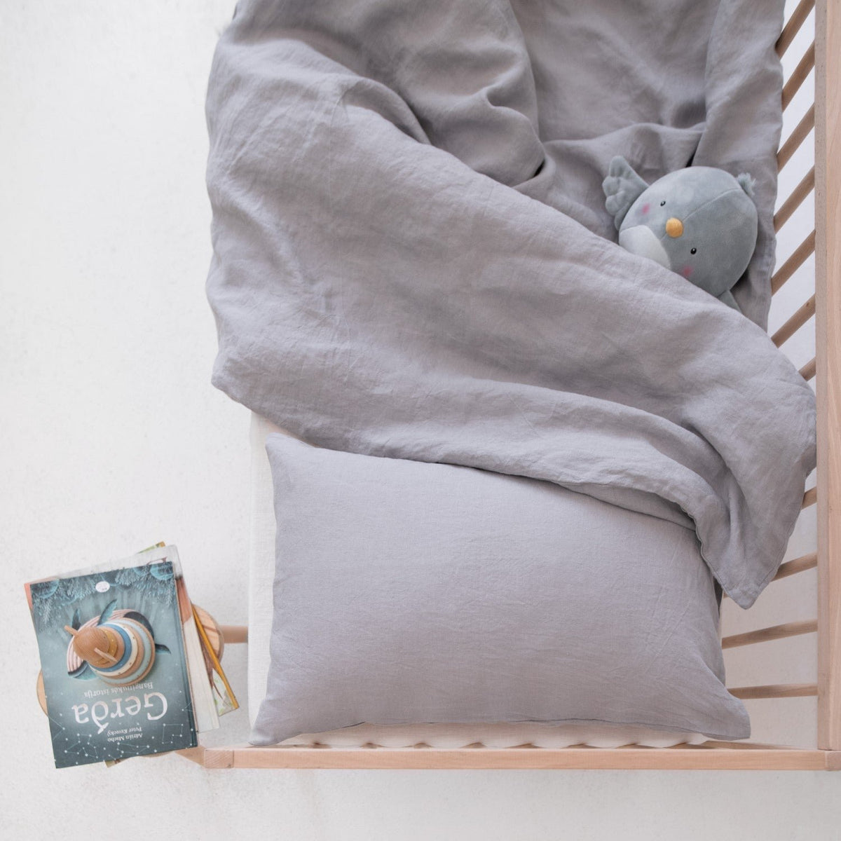 1. Light grey linen duvet cover set in a crib with a plush toy, creating a cozy and inviting children's bedroom setting