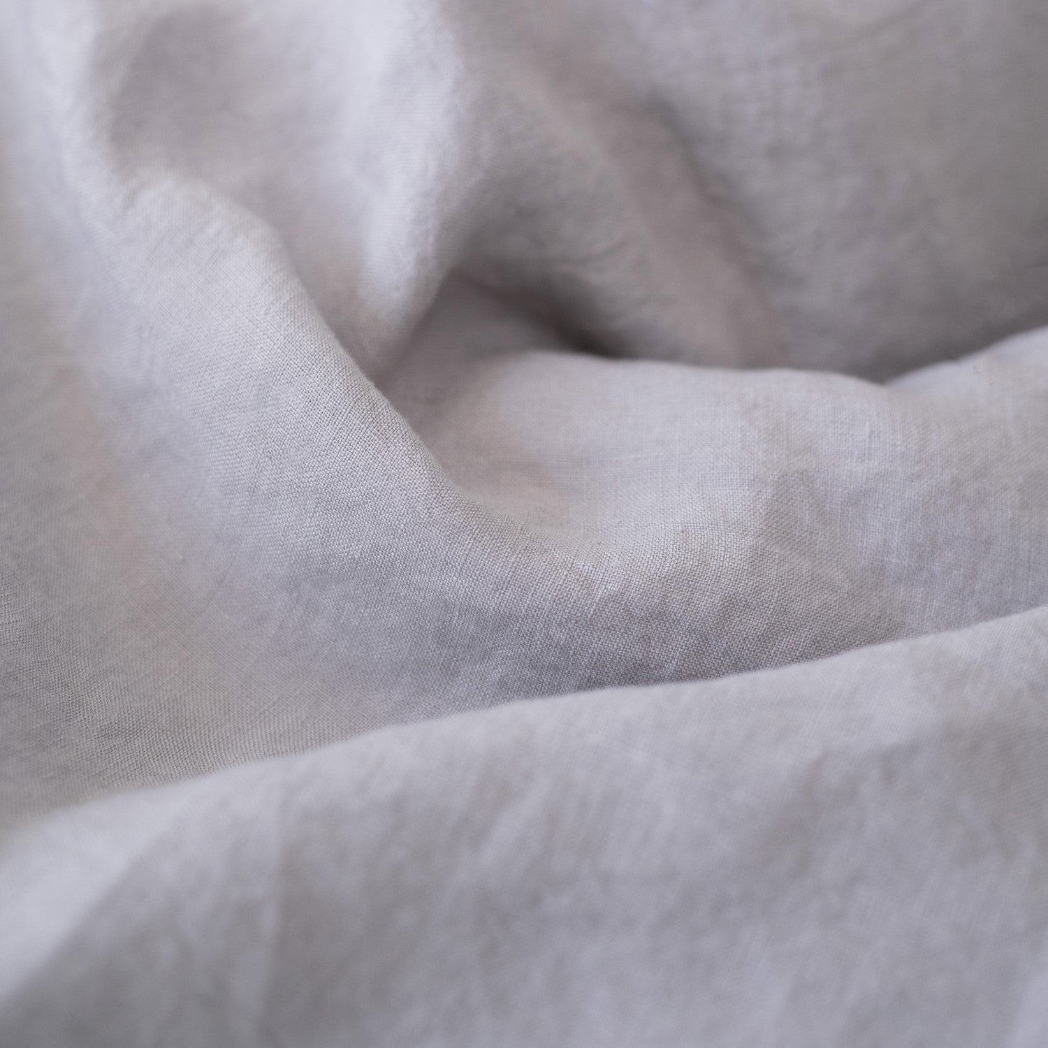 3. Close-up of light grey linen fabric texture, highlighting the softness and quality of the material