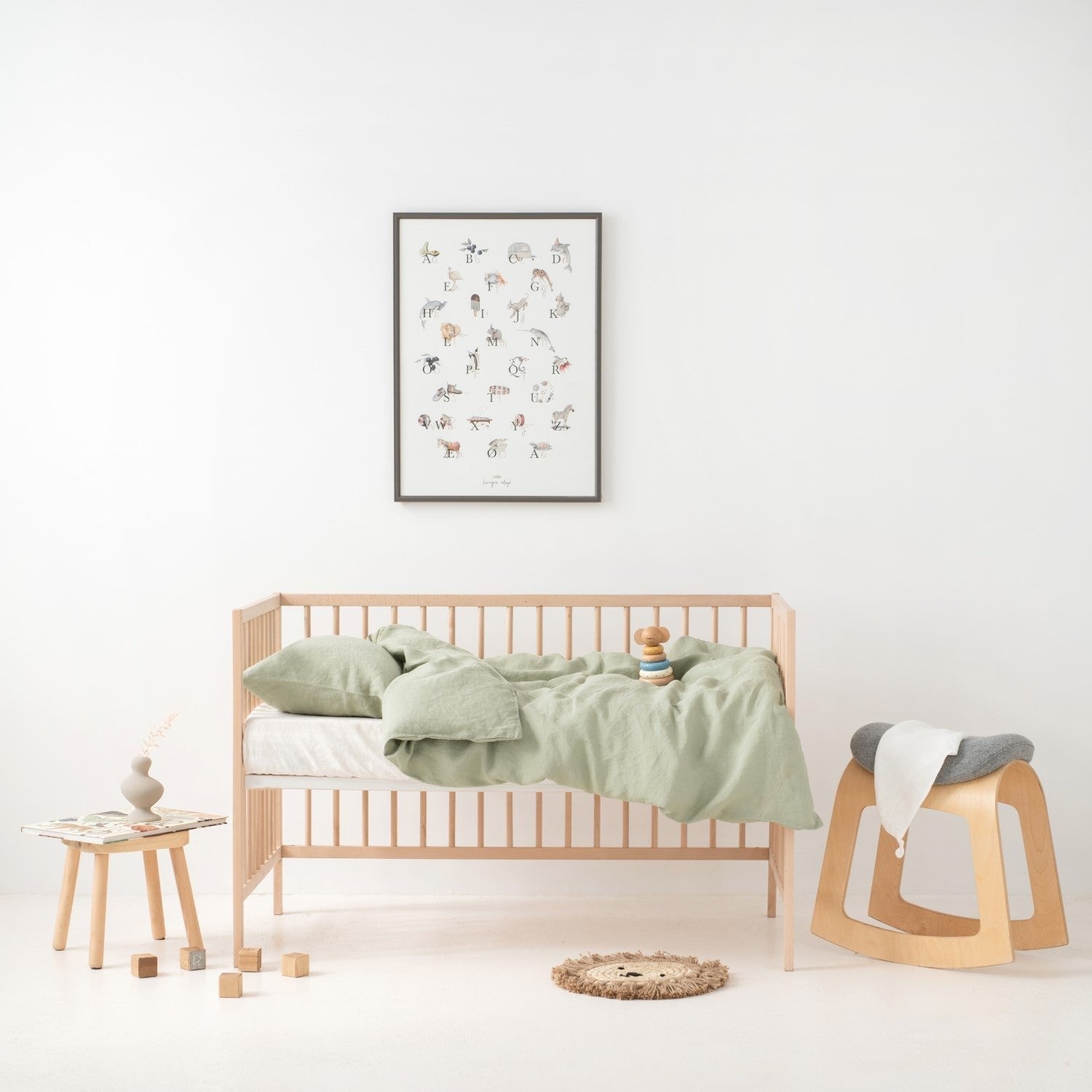 6. Kids' room with crib featuring sage green linen duvet cover set, wooden toys, and decor