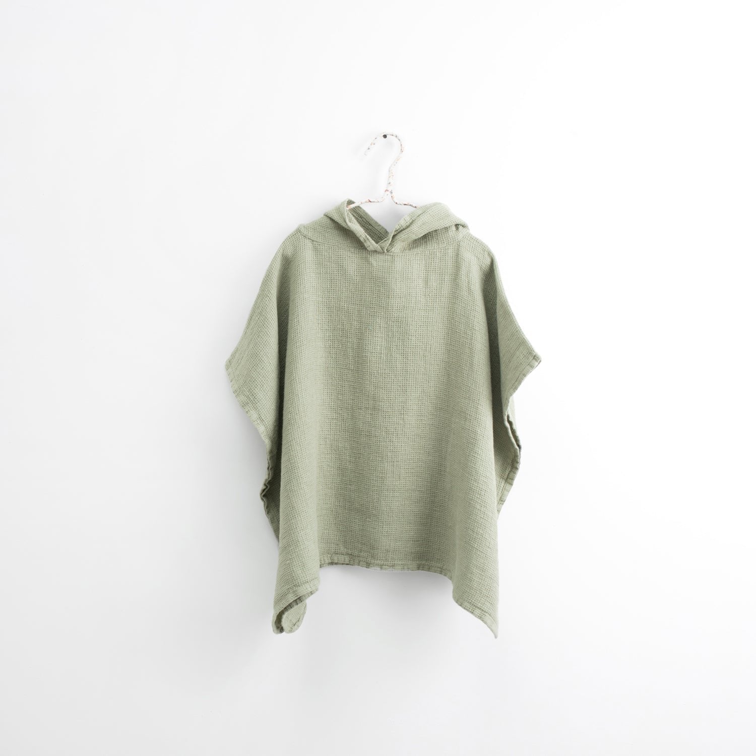 2. Kids' sage green linen poncho with hood on white background, showcasing fine waffle texture