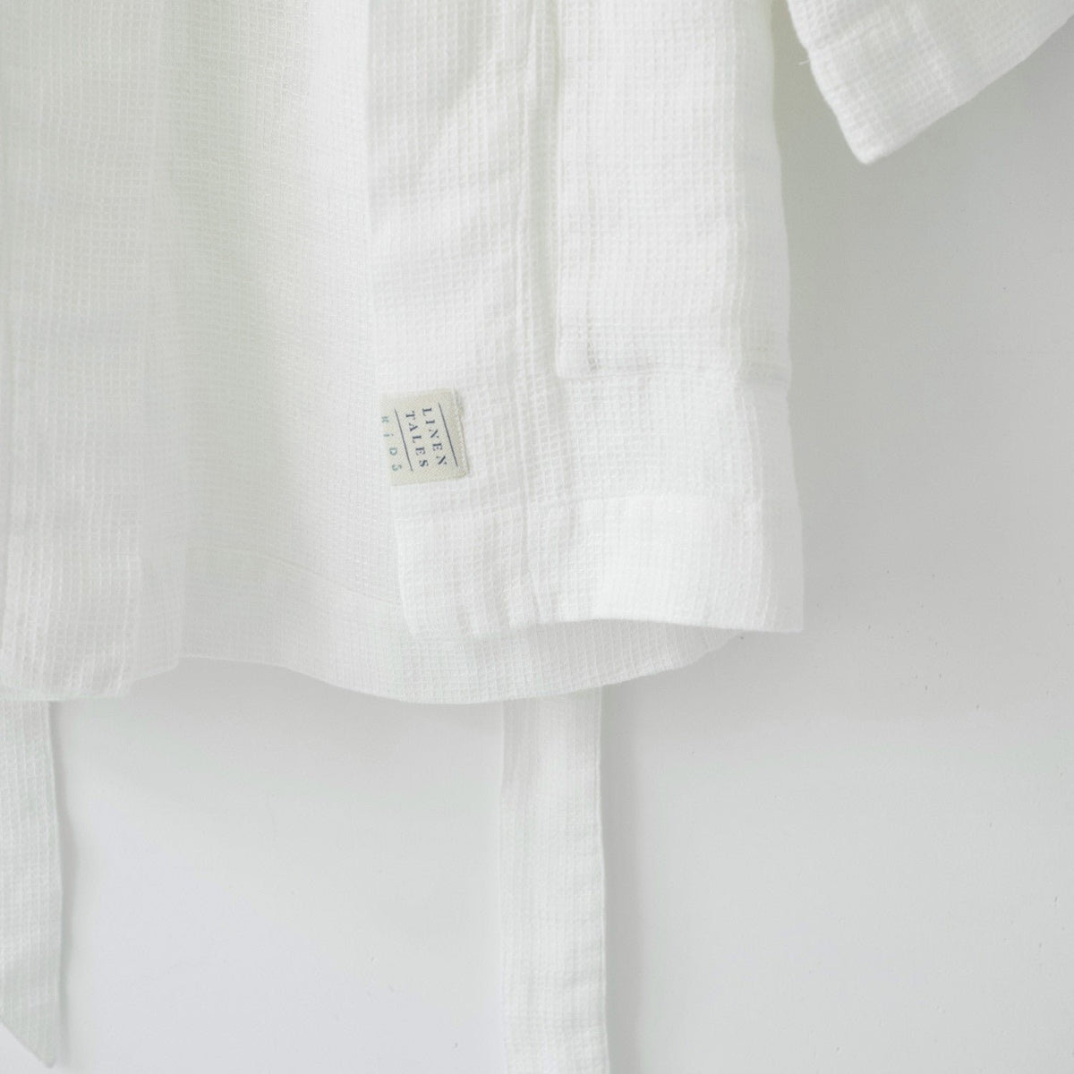 3. Close-up of white linen bathrobe showing Linen Tales label and waffle texture