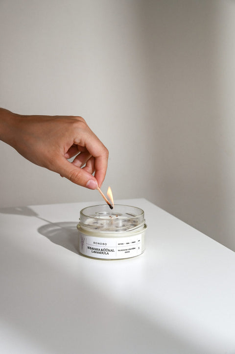 4. Hand lighting BONOBO Scented Candle Lavandula on a white surface
