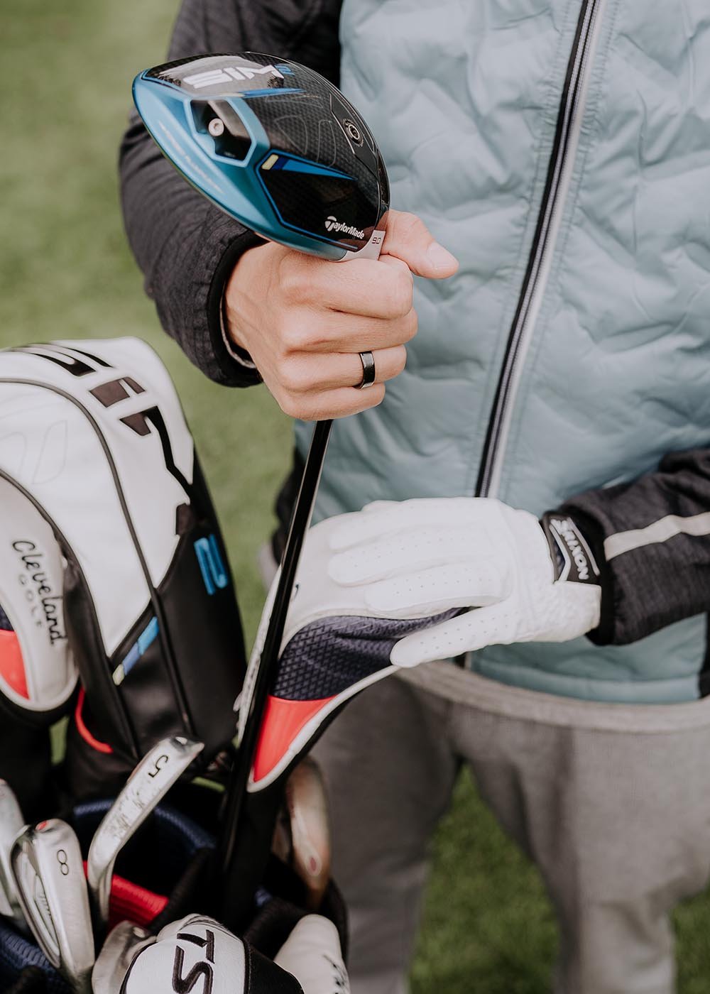 3. Close-up of man wearing Leomani black ceramic ring while holding a golf club