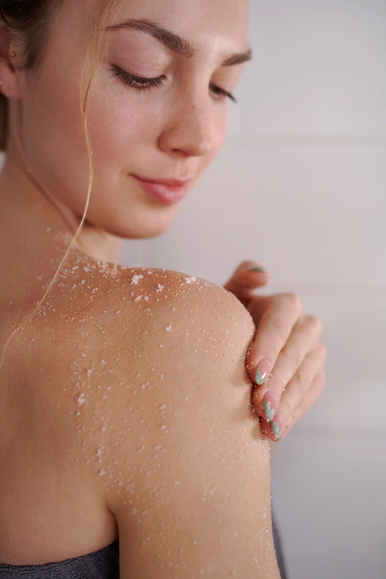 4. Close-up of woman using Magrada Organic Cosmetics Lavender Body Scrub on shoulder, highlighting exfoliating texture
