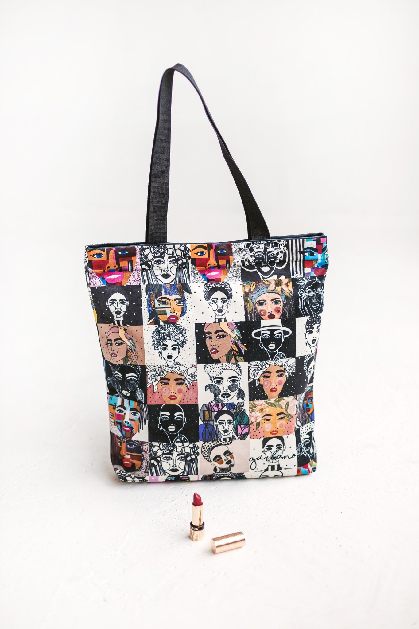 4. Close-up of Garbanota handbag mosaic colored with graphic paintings, shown with lipstick for scale
