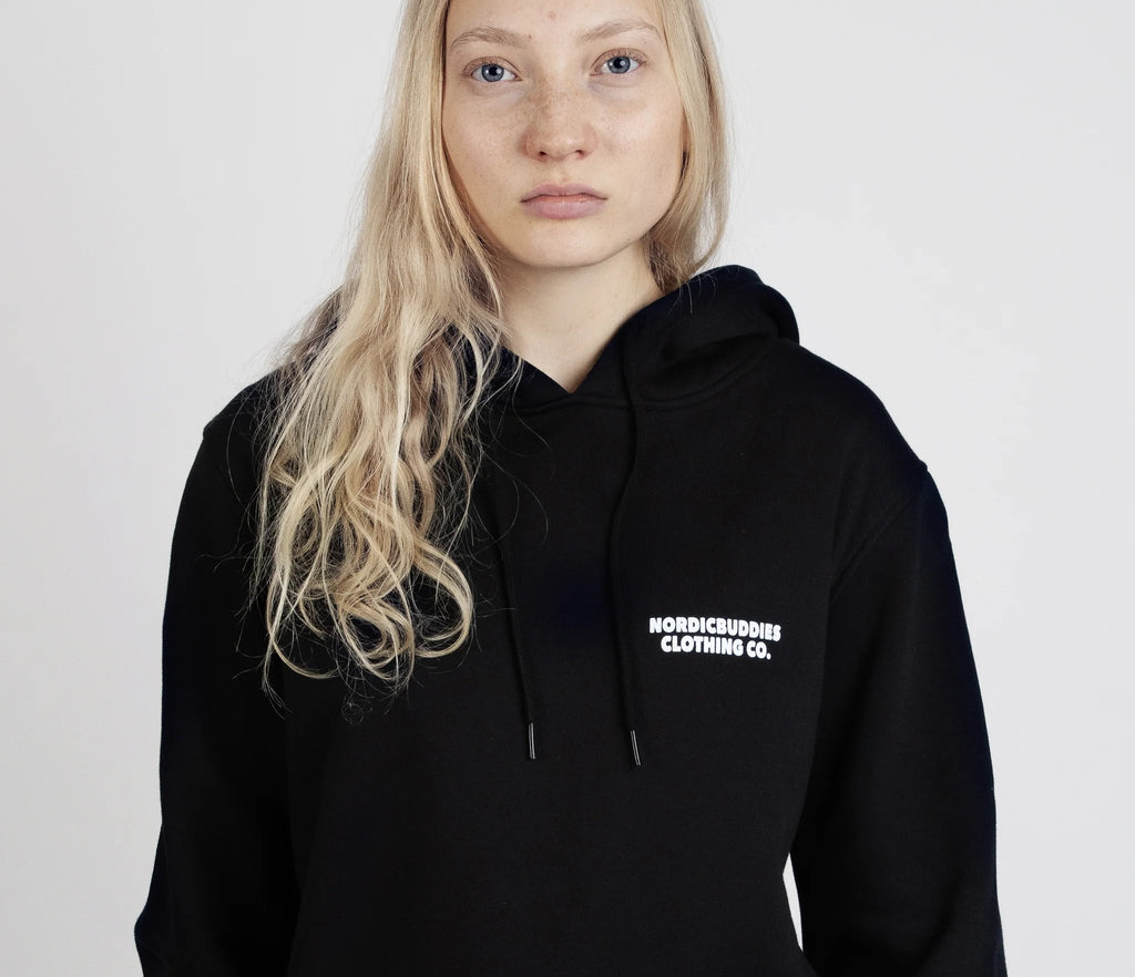 5. Close-up of female model wearing unisex black Moomintroll's Temper Hoodie with NordicBuddies logo