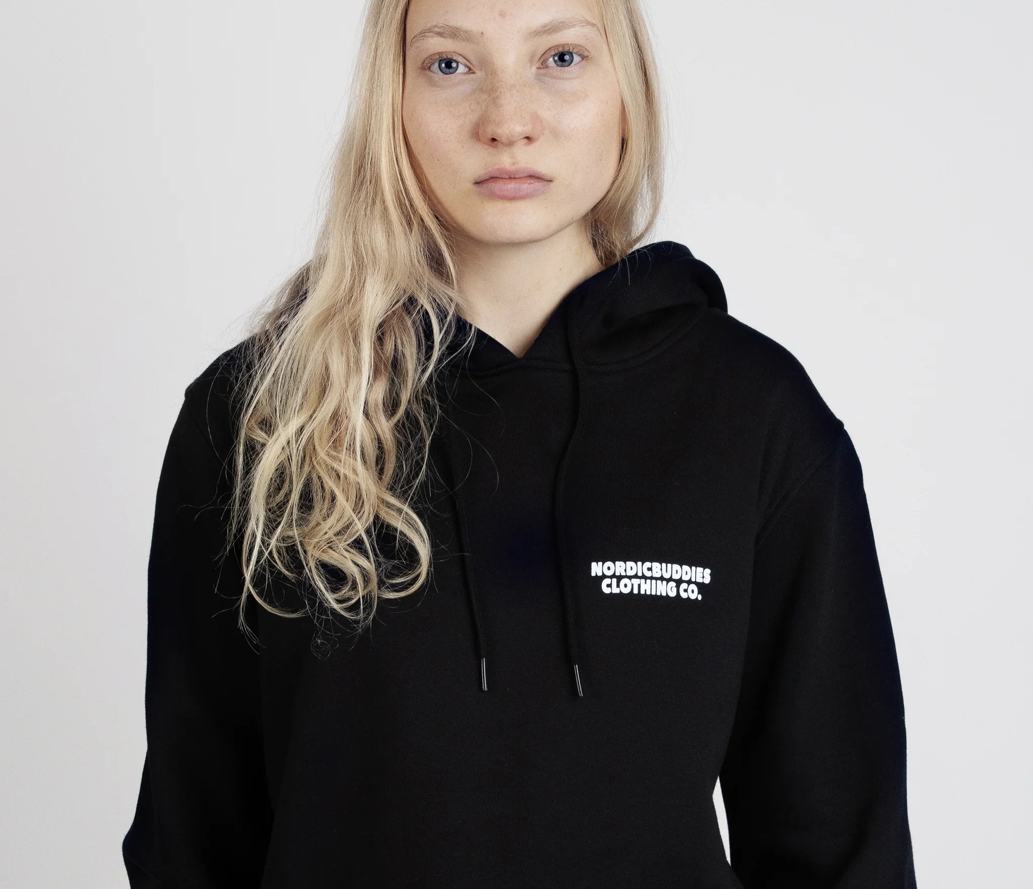 5. Close-up of female model wearing unisex black Moomintroll's Temper Hoodie with NordicBuddies logo