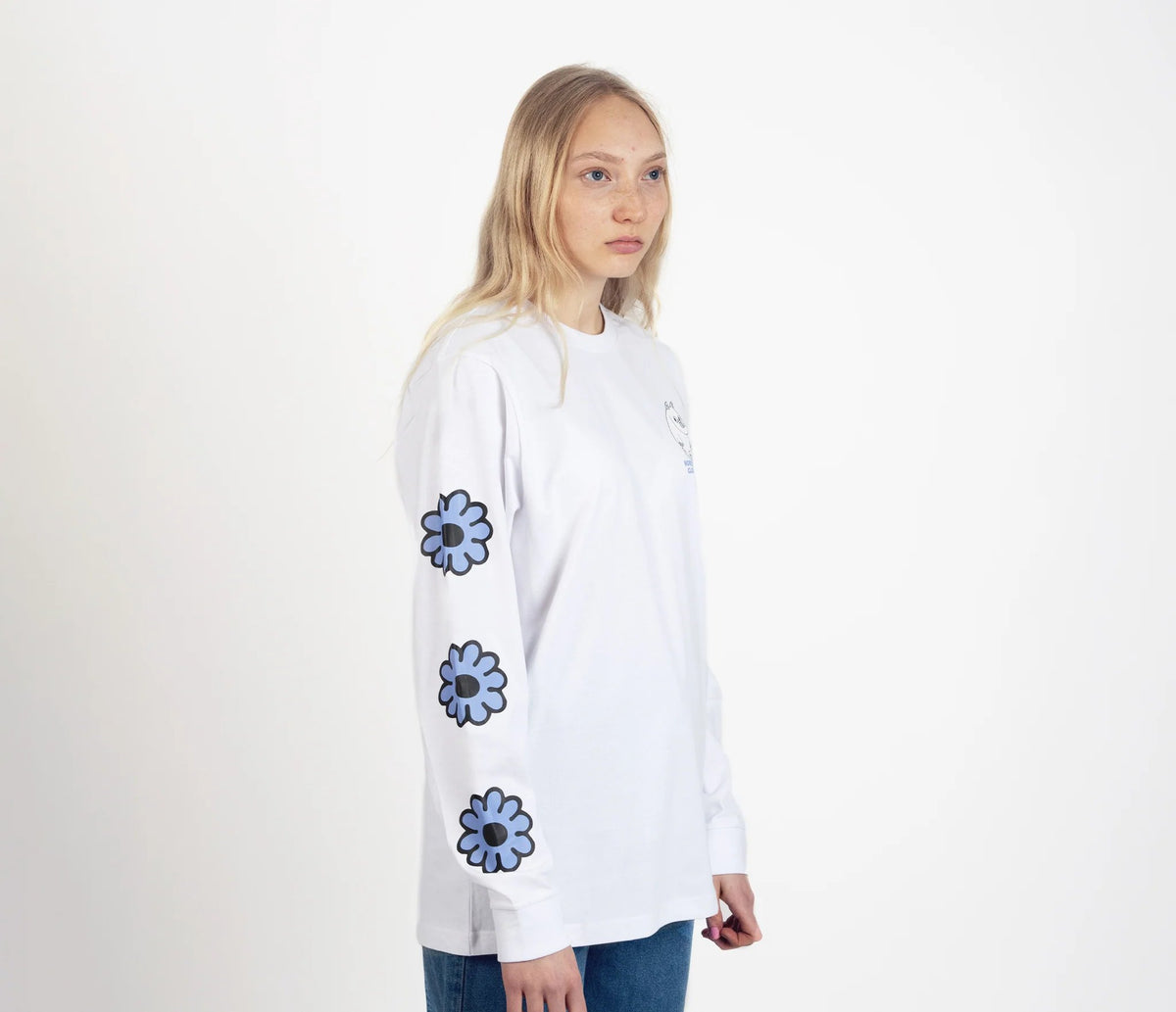 4. Unisex white Moomintroll's Flower longsleeve shirt worn by female model, side view with blue floral sleeve design and cuffrib