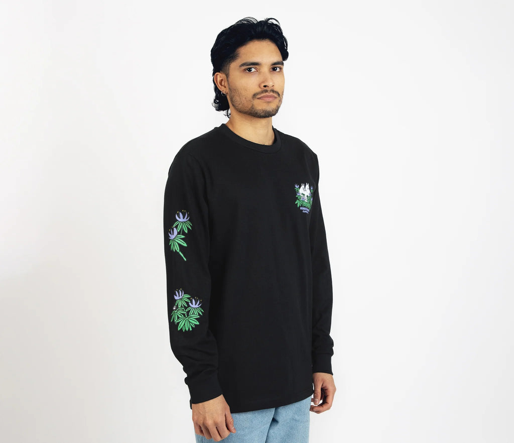 6. Male model wearing Moomin by NordicBuddies black longsleeve shirt with cuffrib, side view in studio