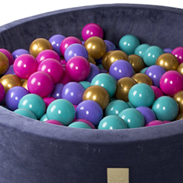 4. Studio shot of blue velvet MeowBaby ball pit filled with colorful balls, surrounded by floral graphics