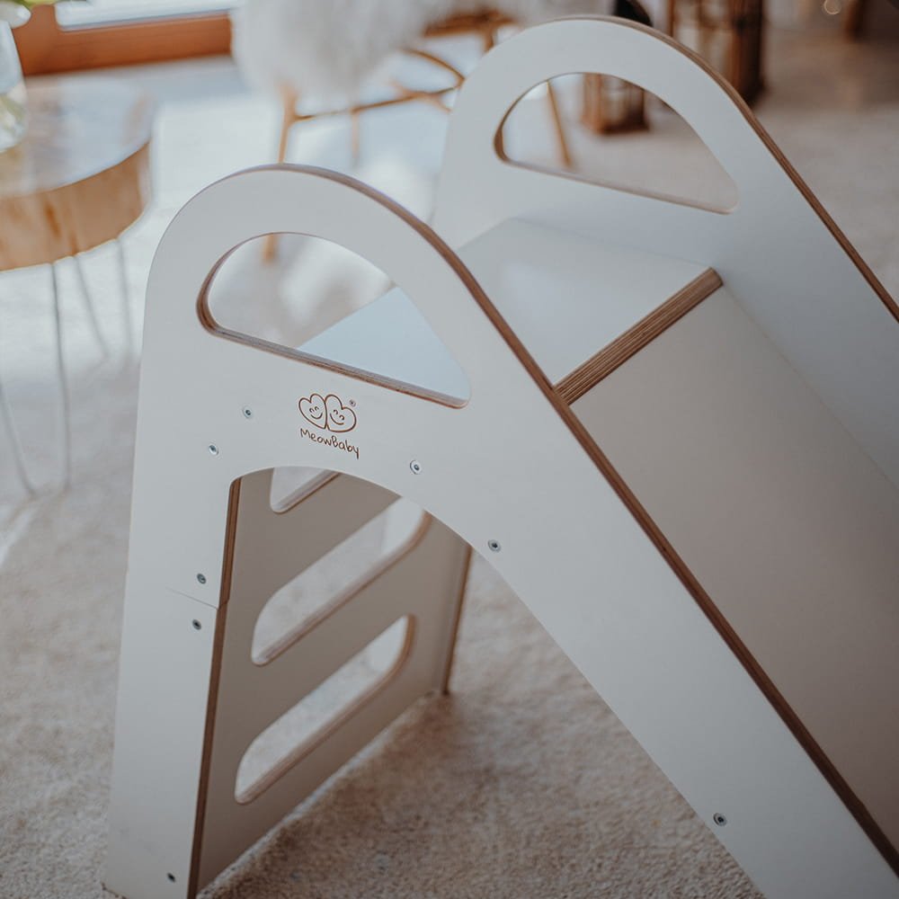 2. Close-up of MeowBaby logo on white wooden slide in a living room