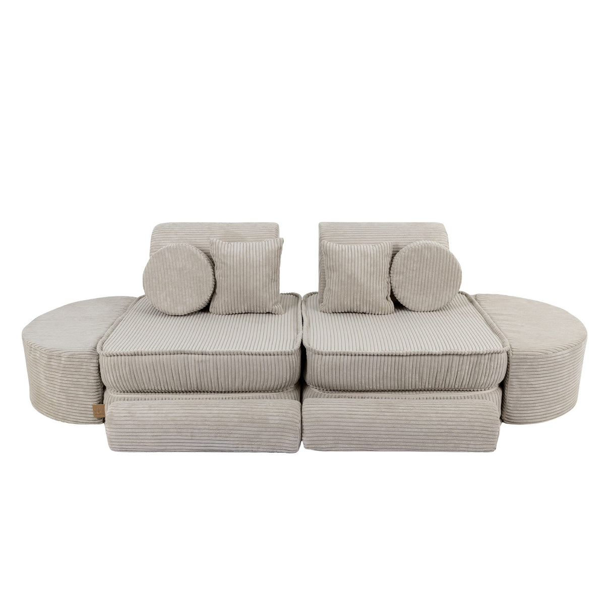 2. Ecru modular sofa for kids with ribbed texture, arranged in a symmetrical layout with circular and square cushions, shown in a studio setting.