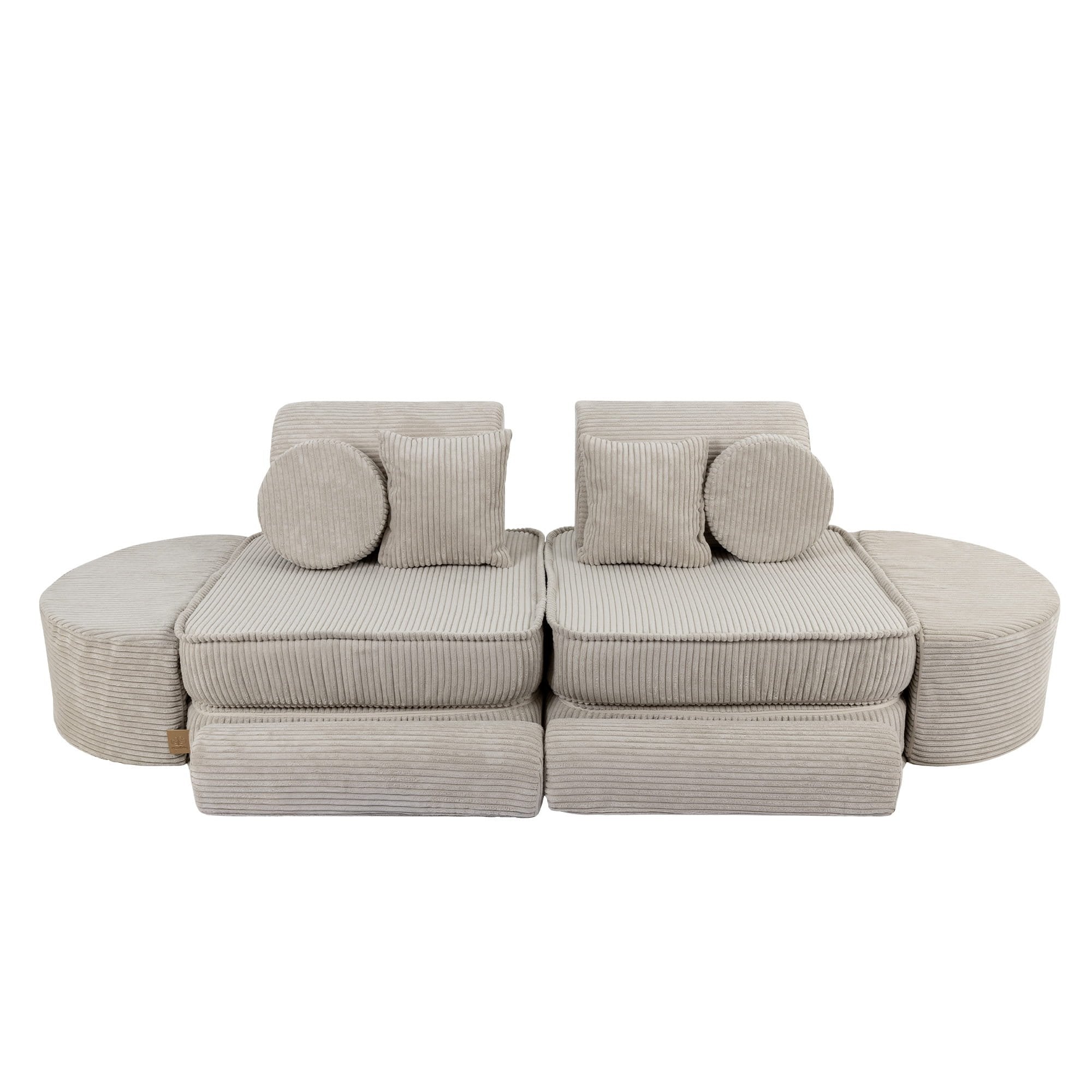 2. Ecru modular sofa for kids with ribbed texture, arranged in a symmetrical layout with circular and square cushions, shown in a studio setting.