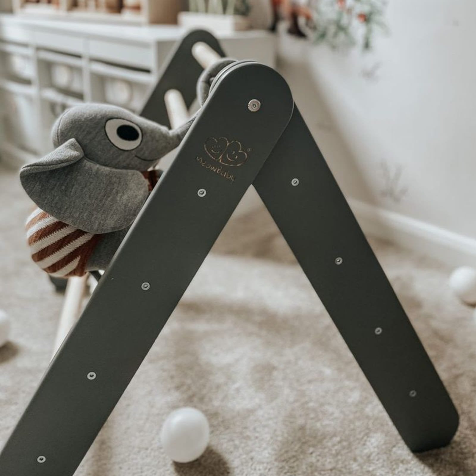2. Close-up of grey ladder house with plush elephant toy on carpeted floor in children's room