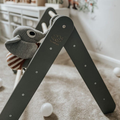 2. Close-up of grey ladder house with plush elephant toy on carpeted floor in children's room