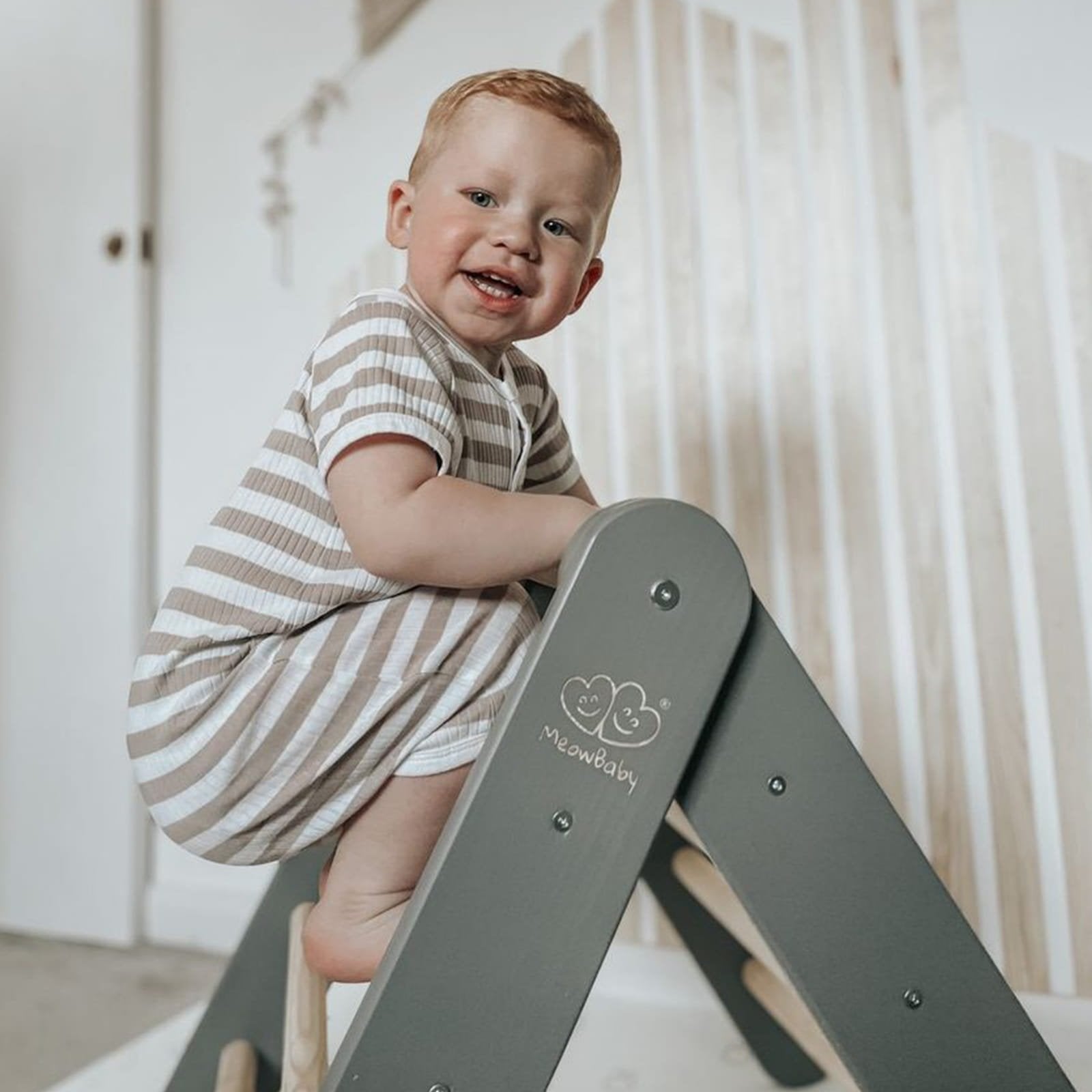11. Child climbing grey ladder house with MeowBaby logo in a nursery setting