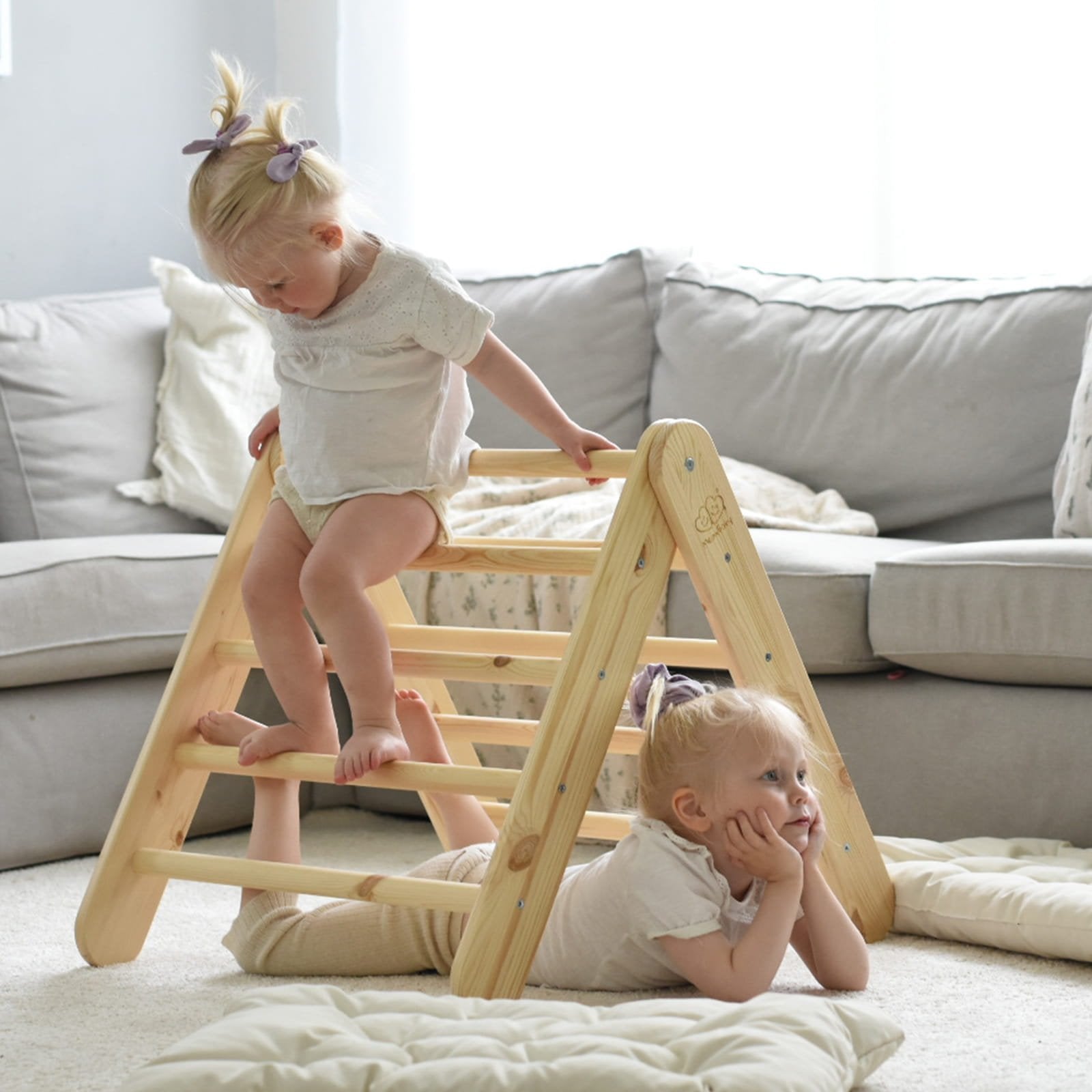 12. Two children playing on natural wood ladder house in living room setting