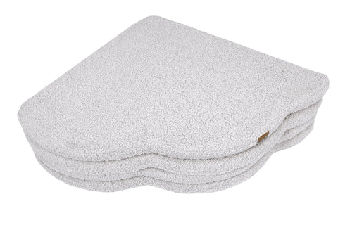 3. Close-up of folded cloud-shaped play mat in bearly white color, highlighting the textured surface and layered design, on a black background