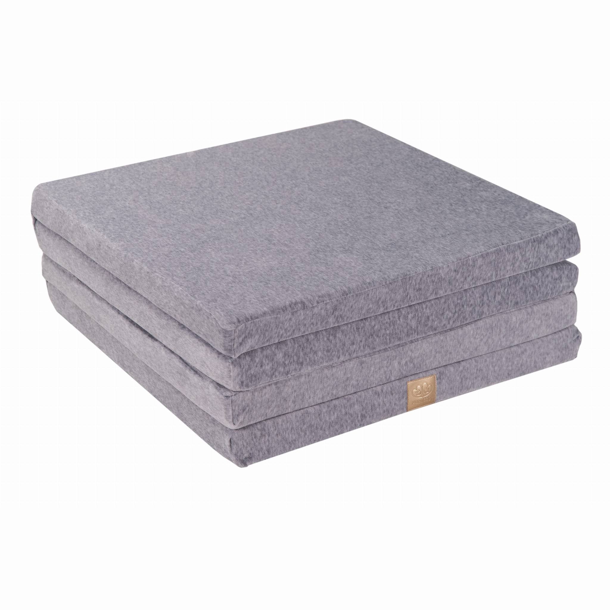 2. Square light grey velvet play mat folded into a compact stack on a white background