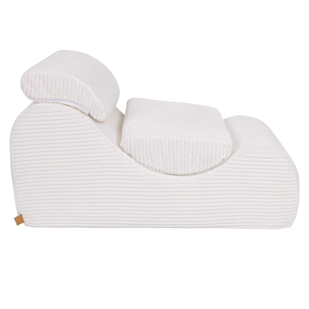 8. Side view of white furrycord Wave Lounger with headrest and footrest, emphasizing design