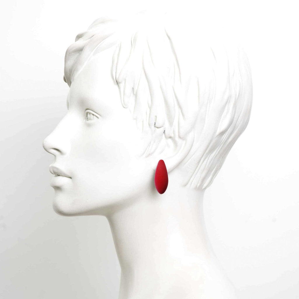 1. Red teardrop-shaped earring from Tanel Veenre's Earberries collection worn by mannequin with short hair on white background