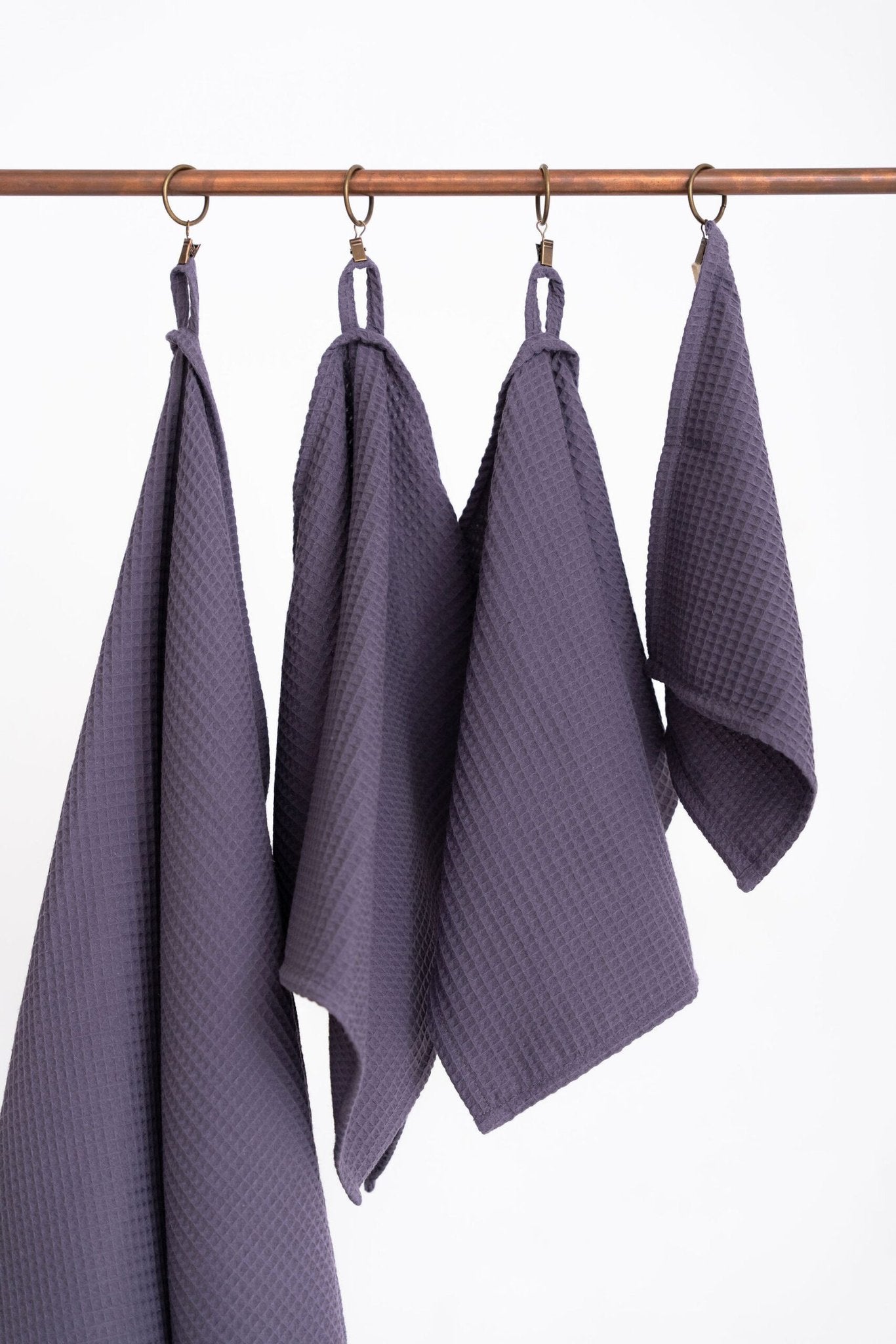 3. Detailed view of purple waffle cotton towels with hanging loops on a rod