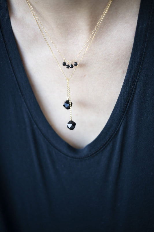 2. Women's layered Tied To Coco - Onyx necklace by New Vintage by Kriss, showcasing faceted onyx stones, styled with a black top