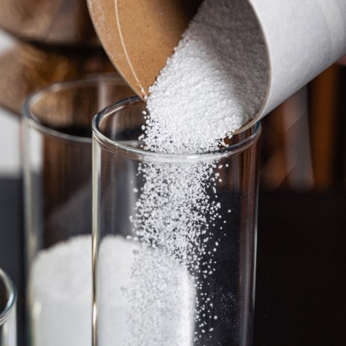 6. Close-up of Candledust powdered candle being poured into a glass container, showcasing texture and ease of use