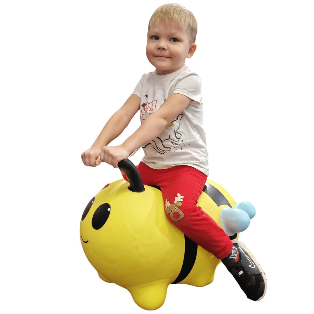 3. Child sitting on yellow bee-shaped hopper toy with black stripes and blue tail on white background