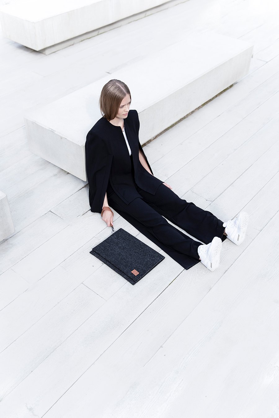 6. Lifestyle image of Nordhale Berg 15'' laptop bag next to a seated model in a modern setting