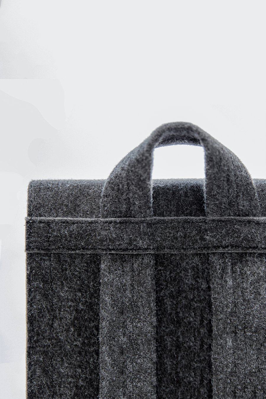 8. Close-up of top handle and straps on black Lund Mini Backpack