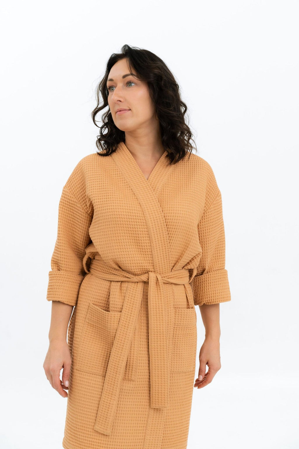 2. Woman in mustard waffle robe with belt, standing with arms relaxed, on a white background