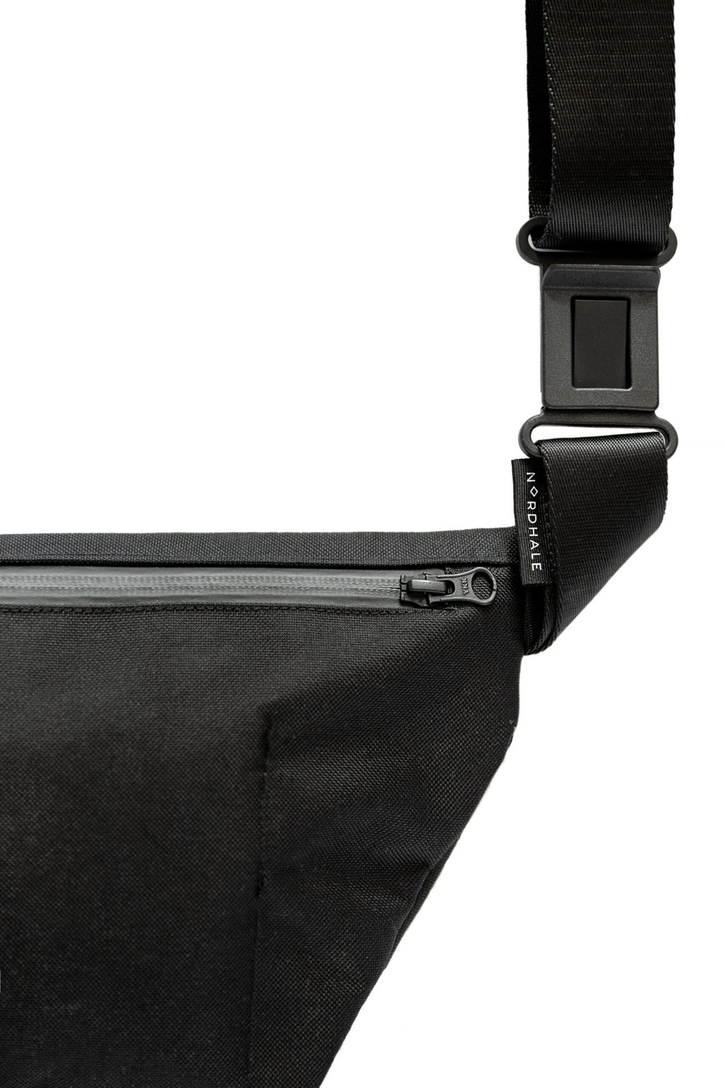 9. Woman wearing Nordhale OSLO Cross Body Bag in black, styled with black outfit, in garden setting