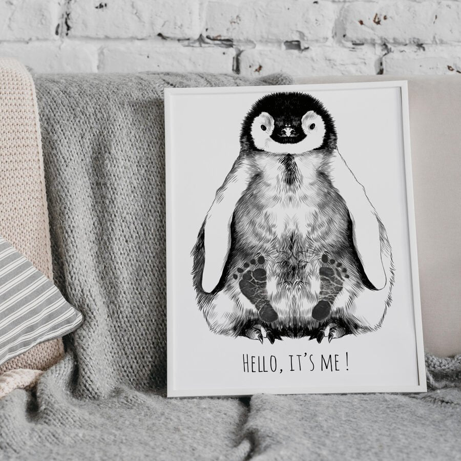 1. Personalized baby penguin footprint kit in white frame with hand-drawn penguin illustration and text 'Hello, it's me!' displayed on a cozy couch with textured blankets.