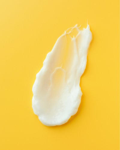 4. Close-up of Nurme body lotion texture on yellow background, highlighting creamy consistency