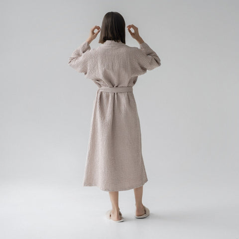 2. Woman shown from back wearing powder-colored honeycomb waffle bathrobe with waist tie, standing in a studio