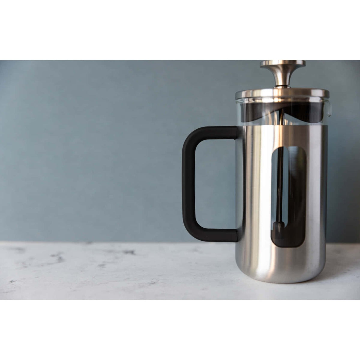 1. La Cafetière Pisa Coffee Maker in silver with black handle on marble surface against blue wall