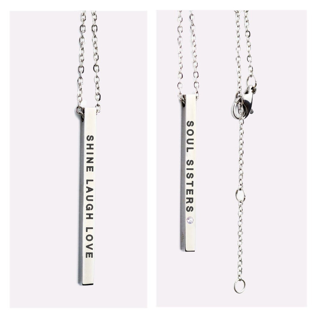 2. Close-up of Olla necklace with double-sided pendant, showing 'SHINE LAUGH LOVE' and 'SOUL SISTERS' engravings in silver