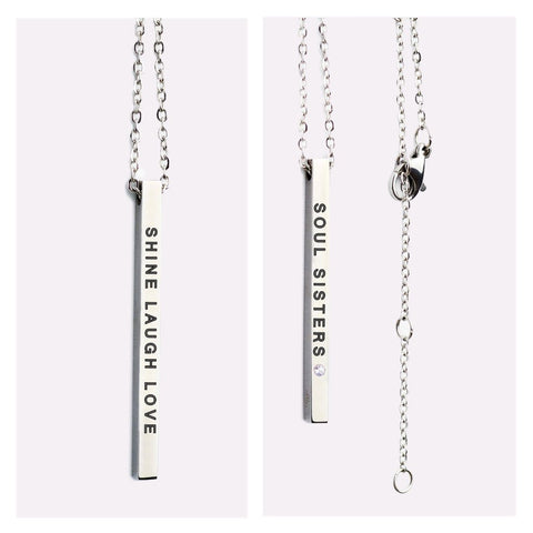2. Close-up of Olla necklace with double-sided pendant, showing 'SHINE LAUGH LOVE' and 'SOUL SISTERS' engravings in silver