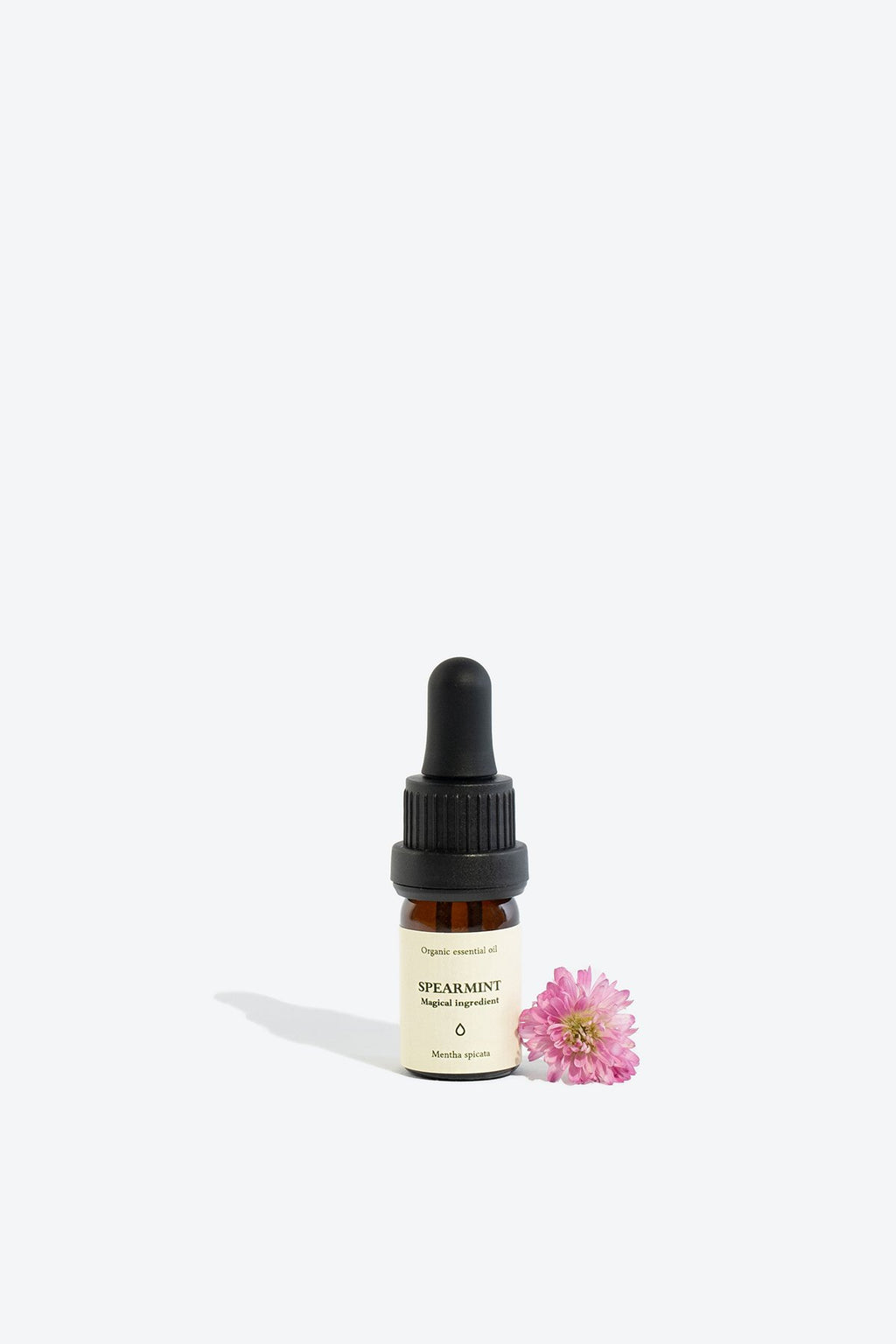 1. Spearmint essential oil in 5 ml glass bottle with pipette, shown with pink flower, by Smells Like Spells