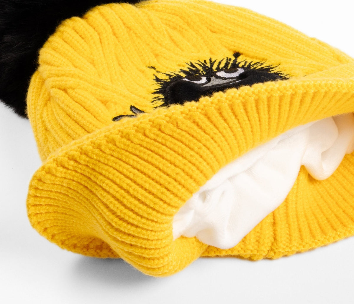 2. Interior view of yellow Stinky Winter Beanie for kids, showing soft fleece lining and embroidered Moomin character