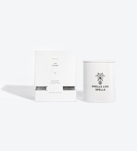 4. Smells Like Spells Scented Candle STRENGTH with packaging, showing Major Arcana VIII Strength, studio setting