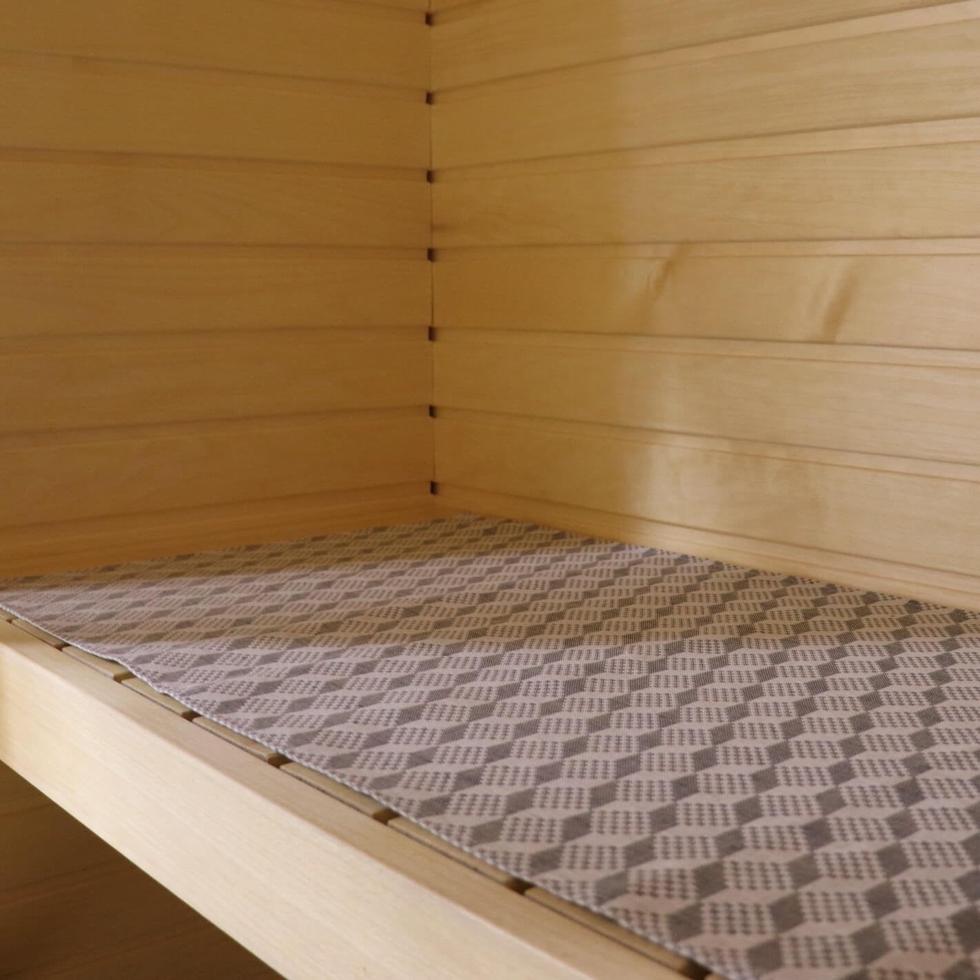 1. Sauna bench with LOKO seating pad featuring traditional Viru County mitten pattern in a light wood sauna setting