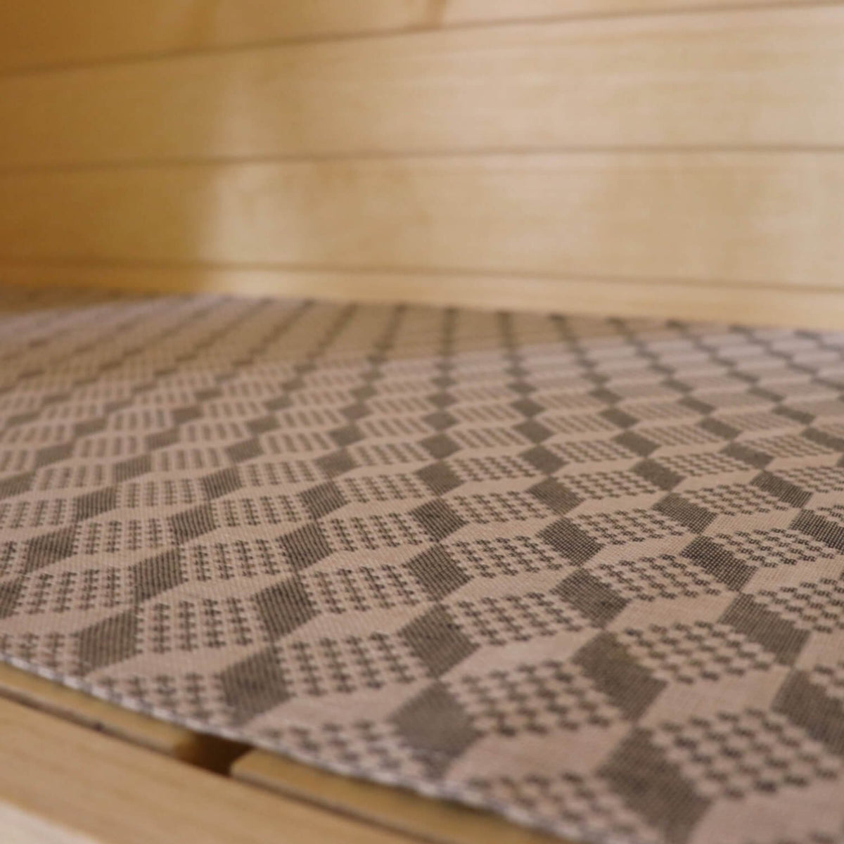 2. Close-up of LOKO sauna seating pad showing detailed Viru County mitten pattern on linen-cotton fabric
