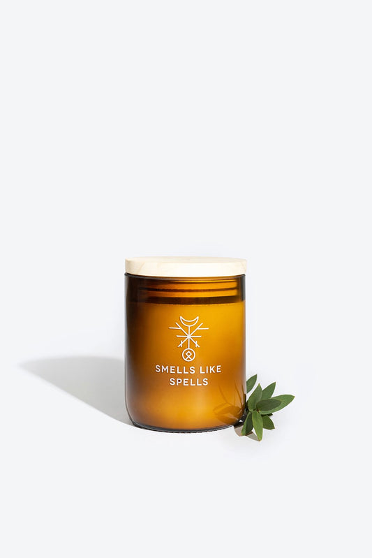 2. Smells Like Spells Scented Candle THOR in amber glass jar with wooden lid and green leaves, studio setting