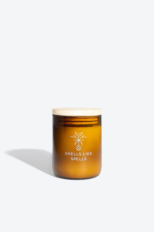 1. Smells Like Spells FREYA scented candle in amber glass jar with wooden lid, studio setting
