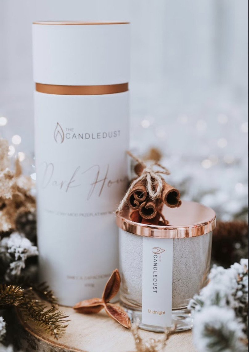 6. Candledust Midnight powdered candle with packaging and cinnamon sticks, festive setting